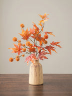 Warm botanisch kunstbloemstuk met esdoornbladeren uit de herfst