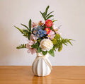 Konstblommig arrangemang - mångfärgade blandade blommor med vit ros och grönska
