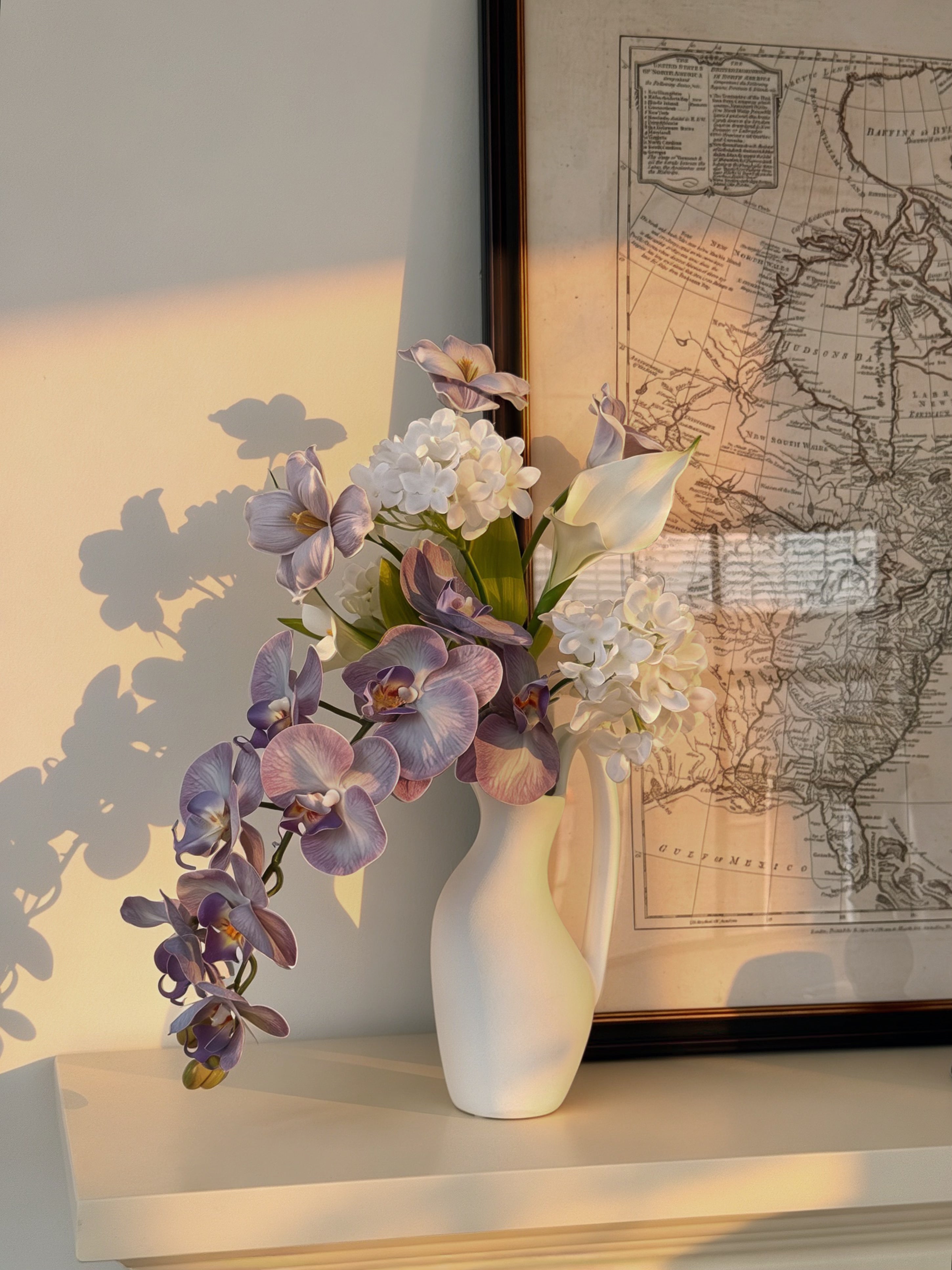 Eteriskt konstgjort blomsterarrangemang med lila orkidéer och tulpaner