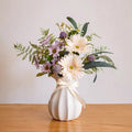 Kunstbloemenschikking met kamille en wilde bloemen