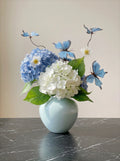 Dromerig kunstblauwe hortensia-arrangement met vlinders