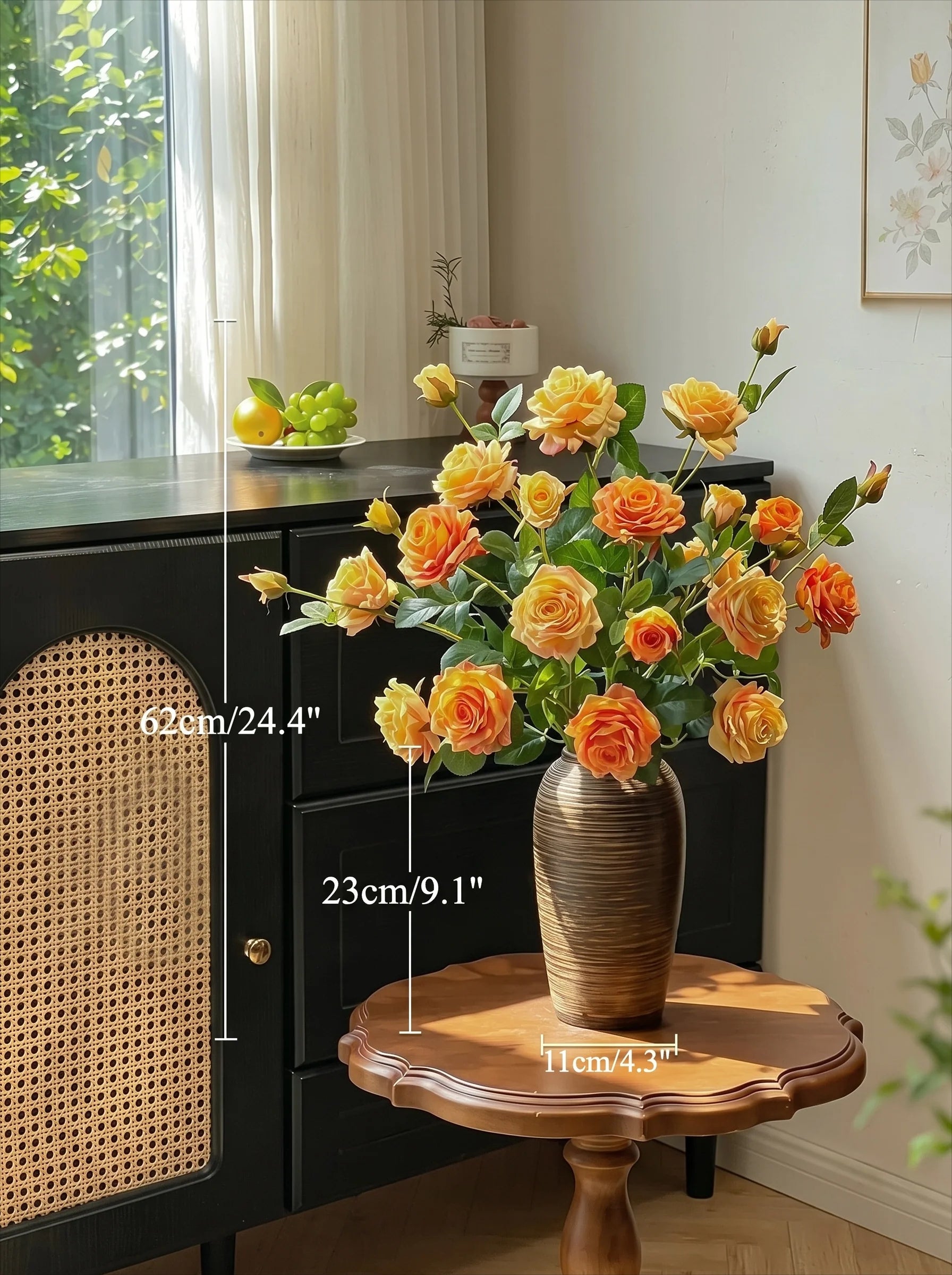 A bouquet of yellow and orange artificial roses in a ribbed brown ceramic vase, displayed on a wooden side table in a styled room with dimension lines showing the bouquet's height, vase height, and base diameter.